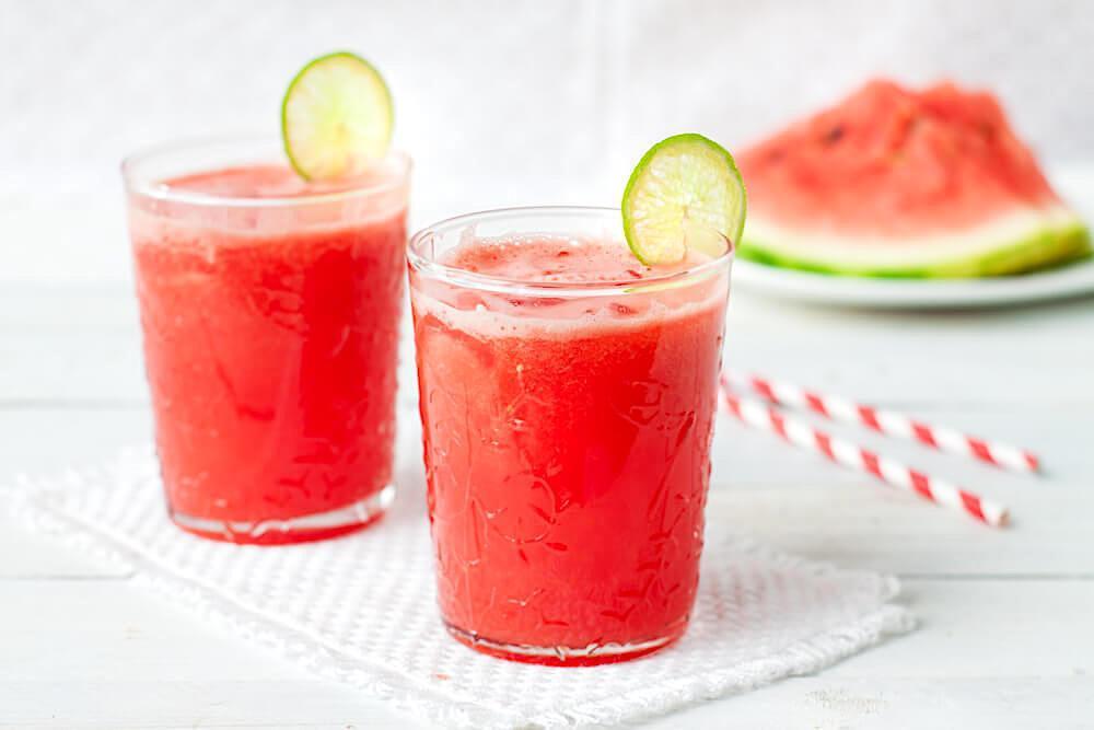 Two glasses of watermelon punch and lime garnish