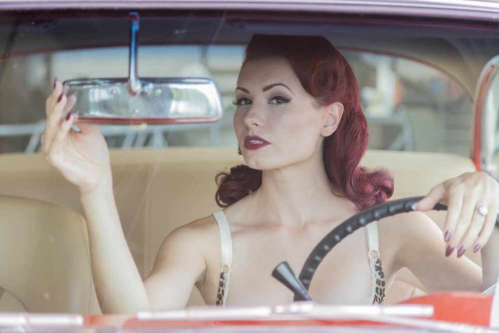 Retro girl with makeup on in car