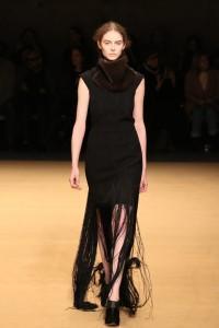 Model walks runway with fringe skirt