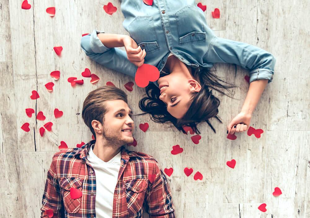 Happy young couple gazing into each other's eyes, surrounded by tiny hearts