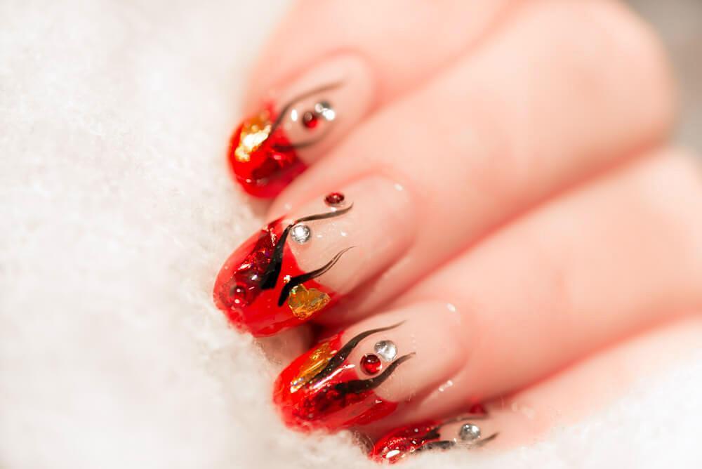 Clear nail art with red accents and design