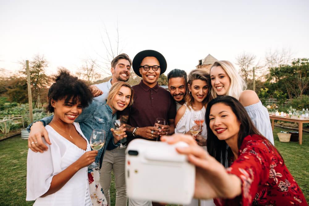 Happy friends taking a picture with an instant camera