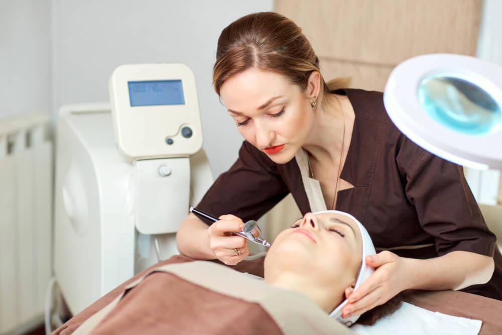 Cosmetologist working on patient's face