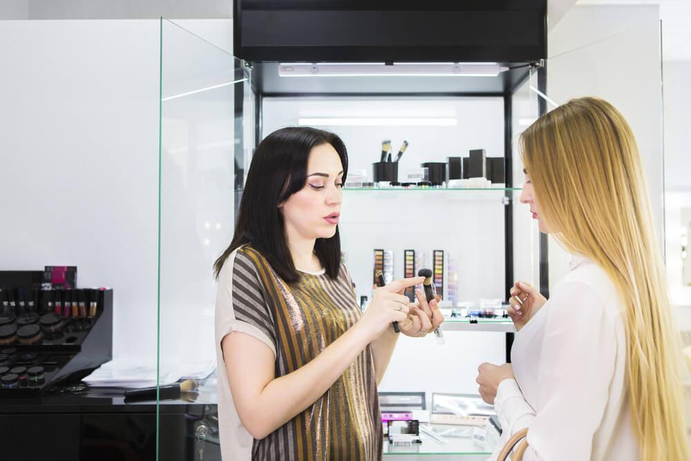 Saleswoman explaining skincare product to customer