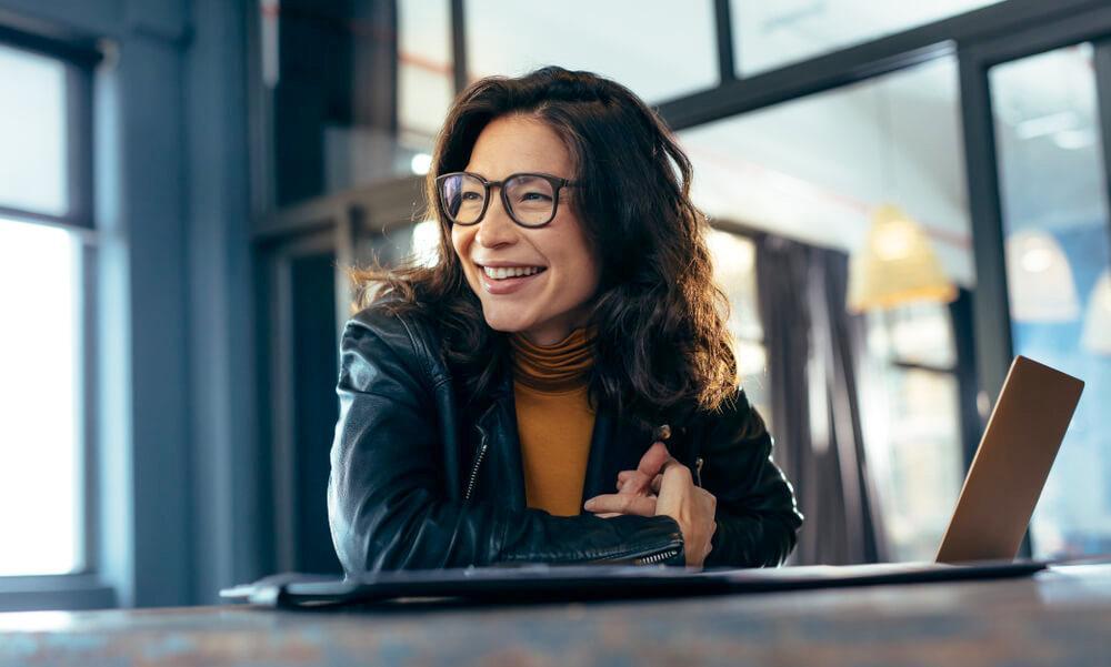 Smiling woman at a desk with her laptop 