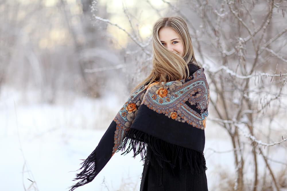 Woman wrapping herself in winter with a long scarf