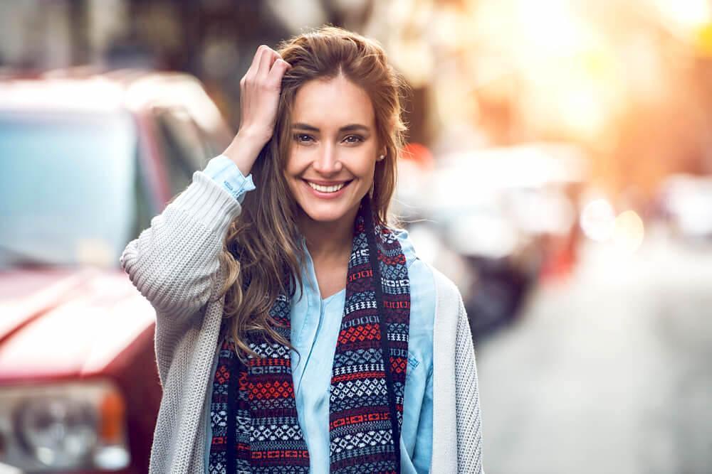 Smiling woman tucking her hair back