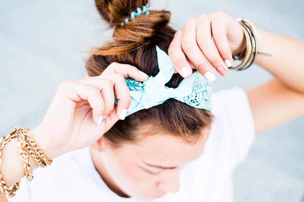 Young woman tying up a hair bow on top of head