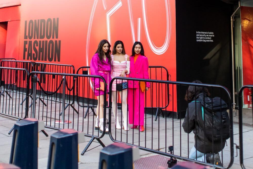 LONDON - FEBRUARY 15, 2019: Stylish ladies wearing pink clothes posing for photographer in front of 180 The Strand for London Fashion Week 2019.