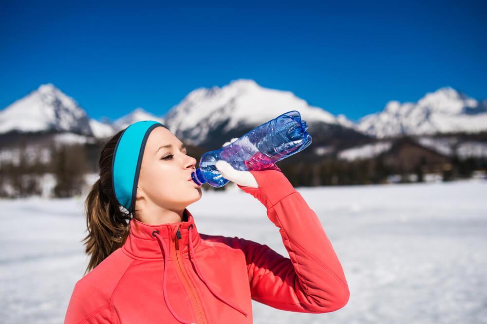 Woman drinking water in snow