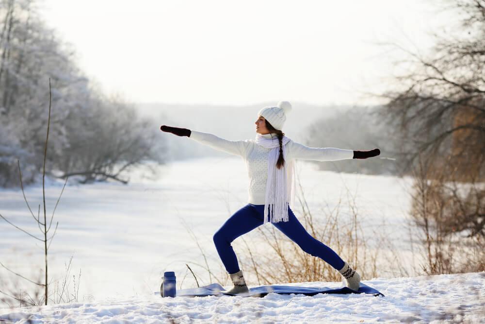 Woman doing yoga in the snow