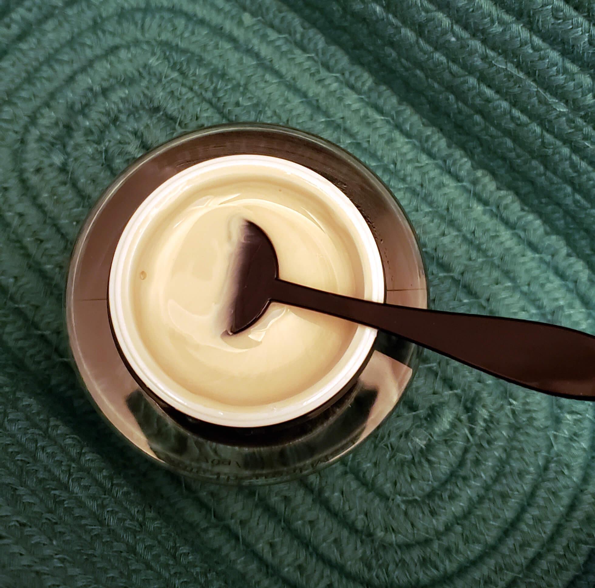 Cream in jar with spoon inside