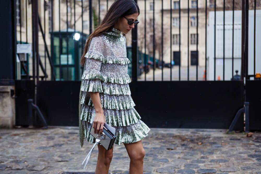 Woman walking along street in sequin dress