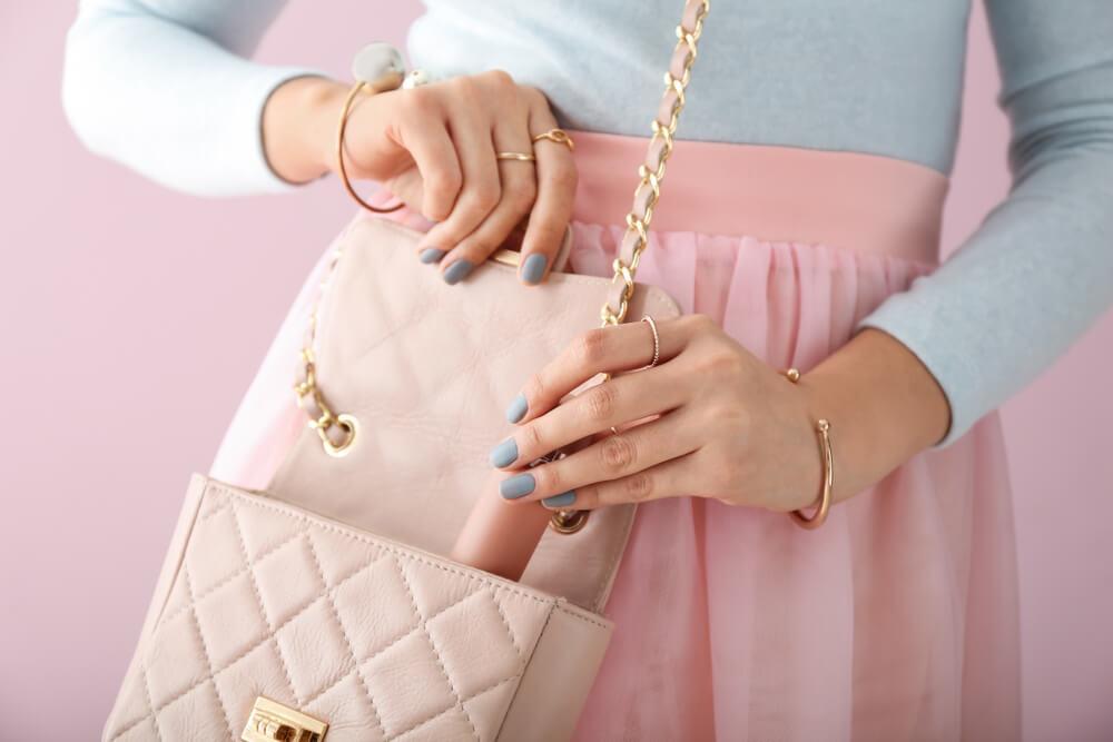 Woman putting purse into bag