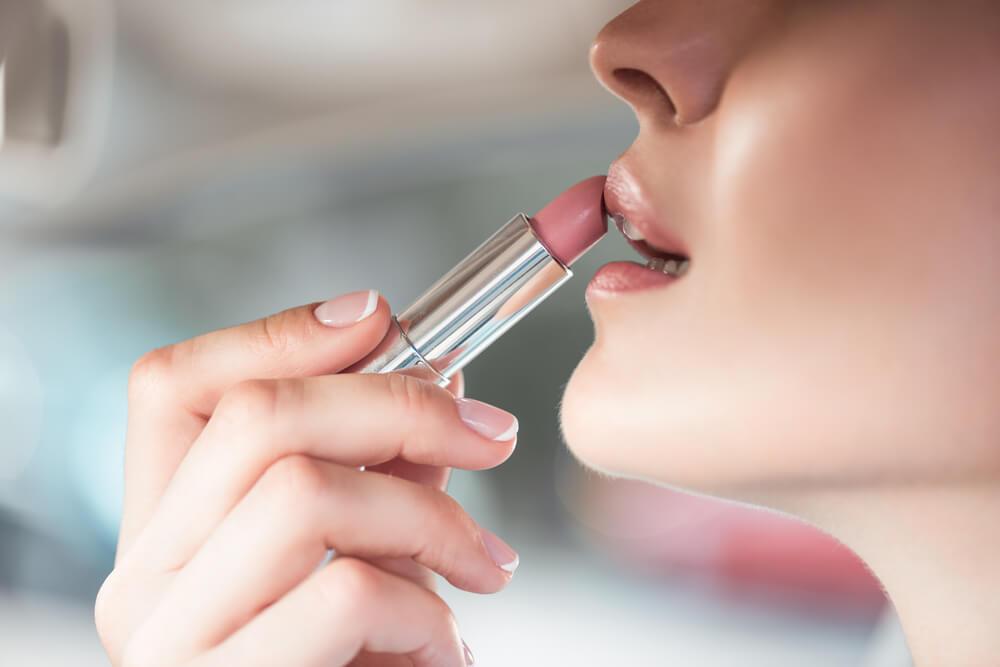 Woman applying lipstick