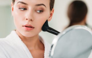 Woman using bronzer on face