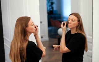 Woman applying makeup and trying to make it not look patchy