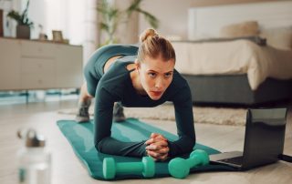 Woman working out with routine on her laptop next to her